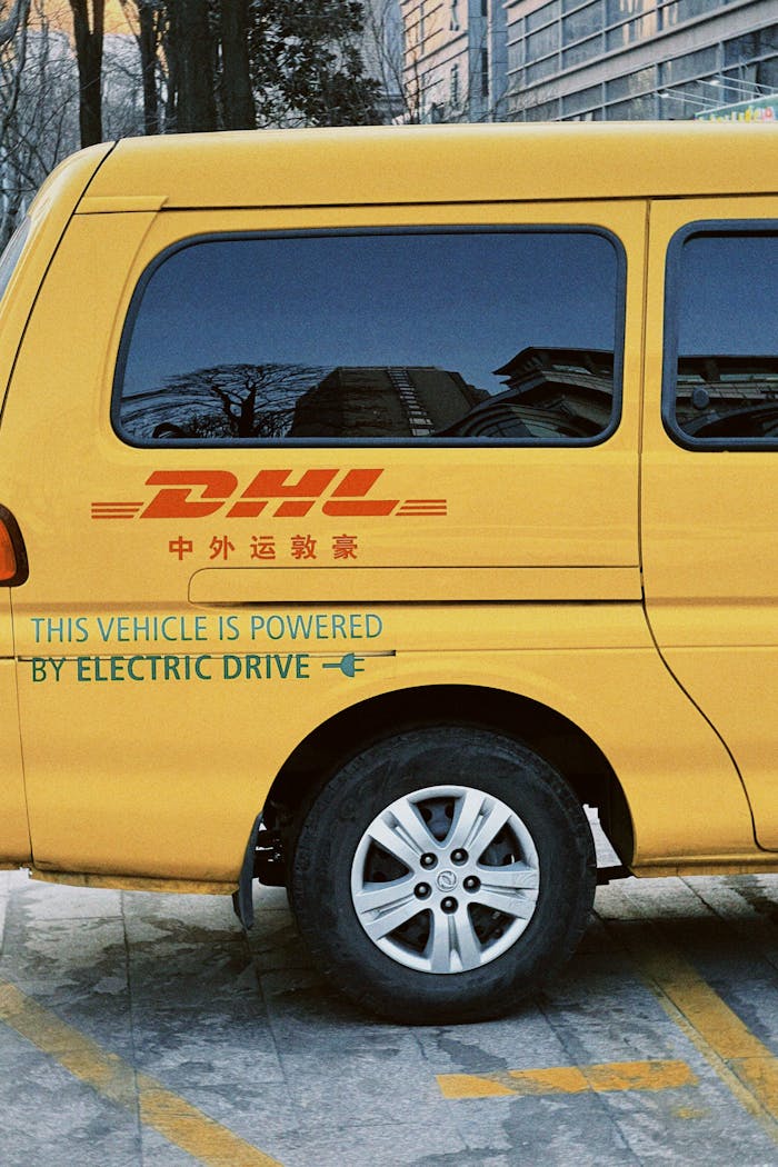The Art of Drawing Readers In: Your attractive post title goes here Yellow electric delivery van with DHL branding parked outdoors. Eco-friendly vehicle.