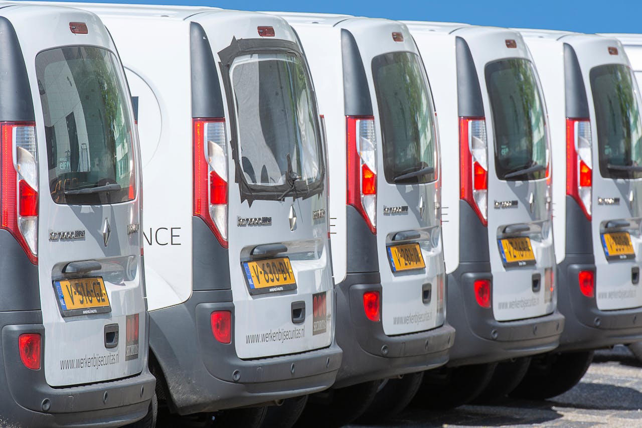 Crafting Captivating Headlines: Your awesome post title goes here A row of white delivery vans parked outdoors, showcasing uniformity and logistics.